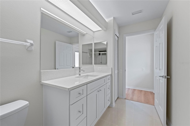 bathroom with tile patterned flooring, vanity, and toilet