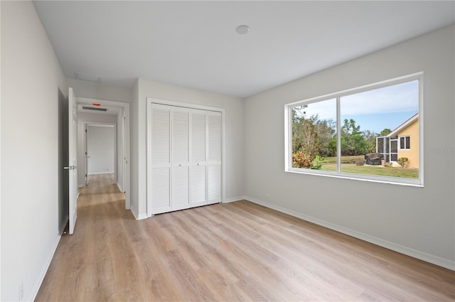 unfurnished bedroom with light hardwood / wood-style floors and a closet