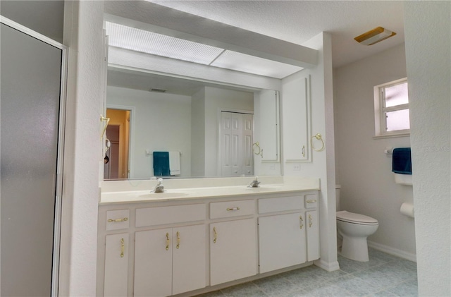 bathroom with toilet, vanity, and walk in shower