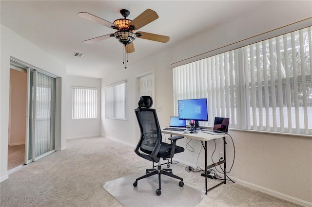 home office featuring light carpet and ceiling fan