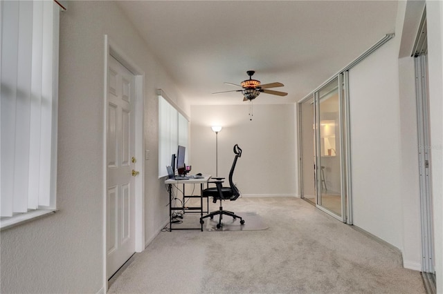 carpeted office space featuring ceiling fan