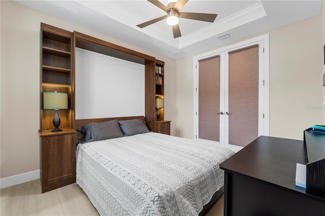 bedroom with ceiling fan, crown molding, and a tray ceiling