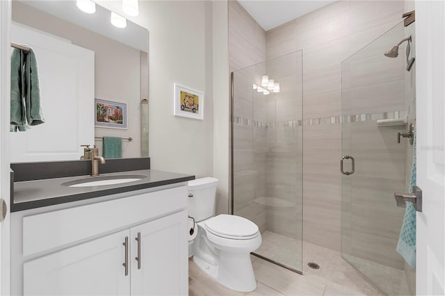 bathroom with toilet, vanity, tile patterned floors, and a shower with door