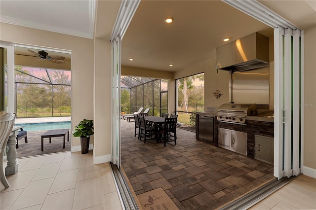 view of patio / terrace featuring glass enclosure, an outdoor kitchen, and area for grilling