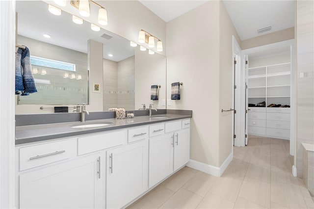 bathroom with a shower, tile patterned floors, and vanity