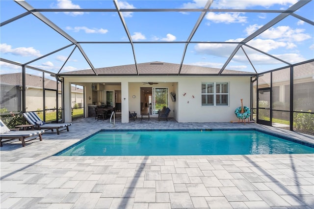 view of swimming pool with ceiling fan, a patio, and a lanai