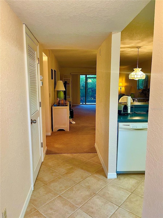 hallway with tile patterned floors and a textured ceiling