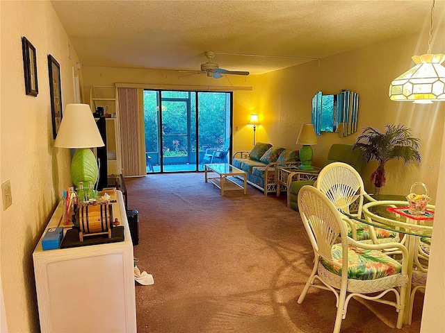 carpeted living room with ceiling fan and a textured ceiling