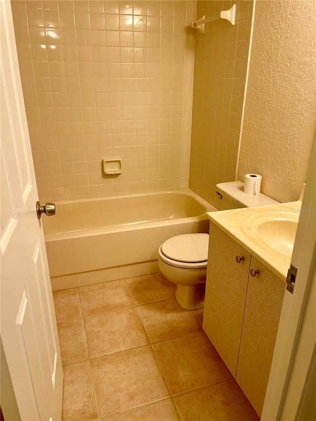 full bathroom with tiled shower / bath combo, vanity, tile patterned floors, and toilet