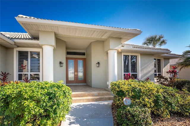 entrance to property featuring french doors and stucco siding