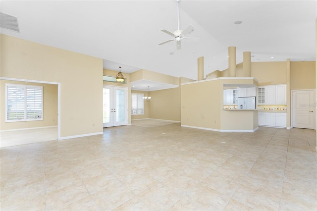 unfurnished living room featuring ceiling fan, french doors, and high vaulted ceiling