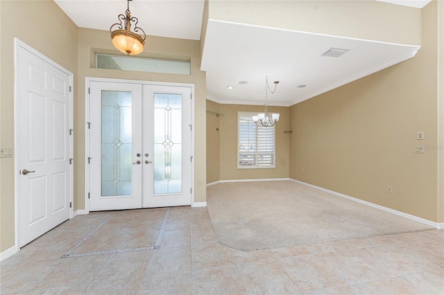 foyer with light colored carpet, french doors, a notable chandelier, and crown molding