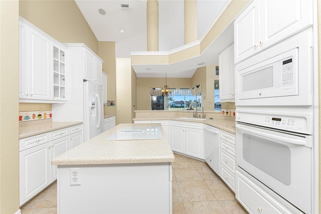 kitchen with a kitchen island, white cabinets, kitchen peninsula, and white appliances