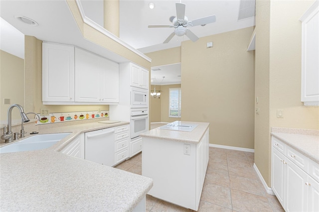 kitchen featuring sink, white appliances, white cabinetry, and a center island