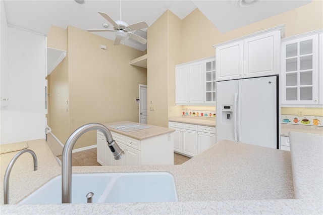 kitchen featuring lofted ceiling, white cabinets, sink, and white fridge with ice dispenser