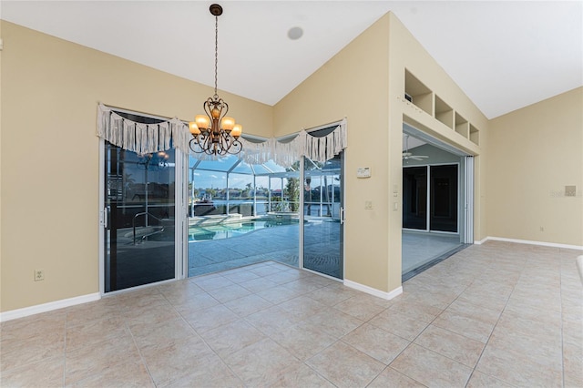 tiled spare room with vaulted ceiling and ceiling fan with notable chandelier