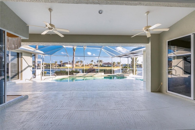 view of swimming pool with ceiling fan, glass enclosure, and a patio