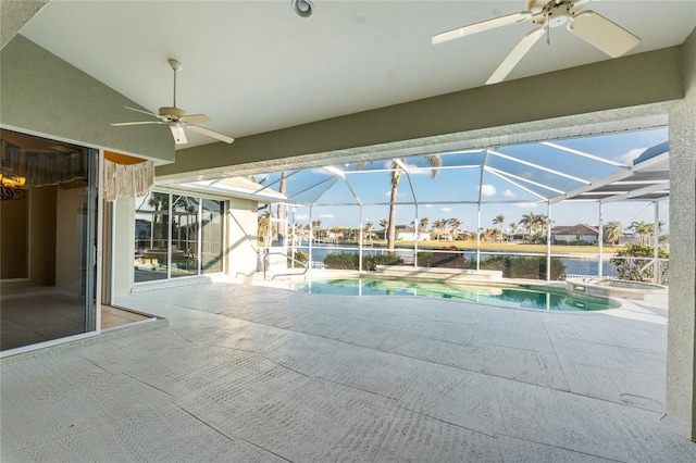 view of swimming pool with glass enclosure, ceiling fan, a patio area, a water view, and an in ground hot tub