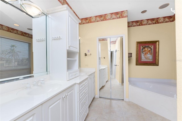 bathroom featuring a bathtub, tile patterned floors, and vanity