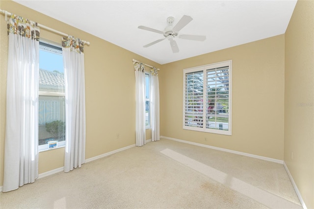 carpeted spare room featuring ceiling fan