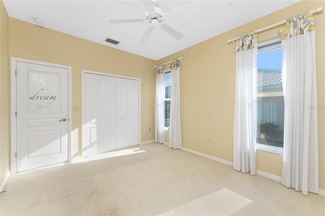 unfurnished bedroom featuring ceiling fan and light colored carpet