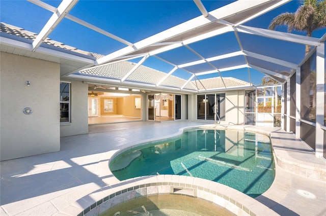 view of pool with a lanai, a hot tub, and a patio