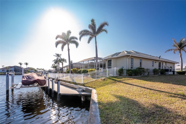 dock area with a water view and a lawn