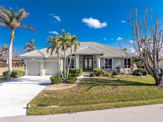 view of front of property with a front yard, french doors, and a garage