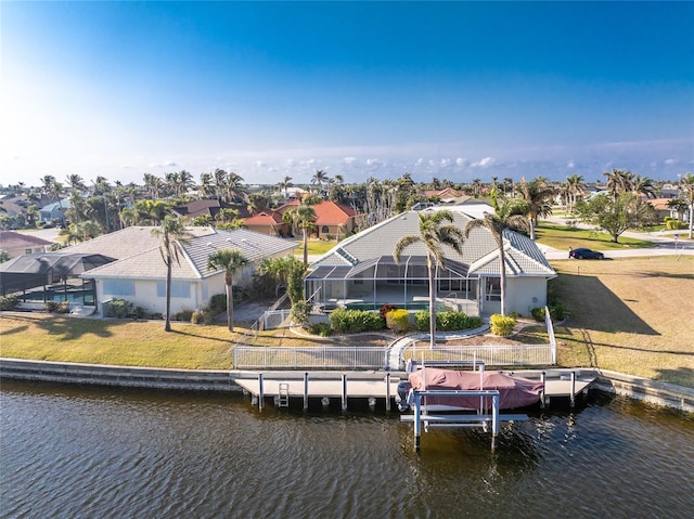 back of house featuring a water view, a lawn, and a lanai