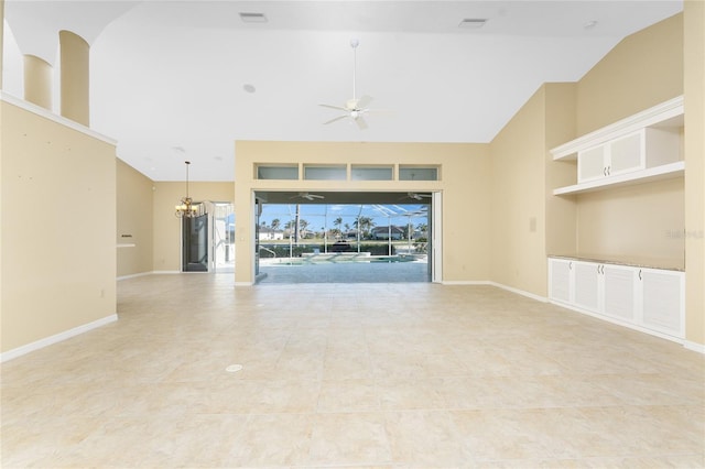 unfurnished living room featuring lofted ceiling and ceiling fan with notable chandelier