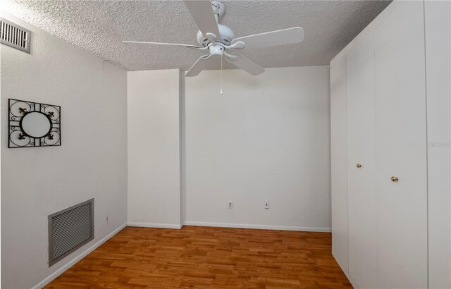 unfurnished room featuring a textured ceiling, ceiling fan, and hardwood / wood-style floors