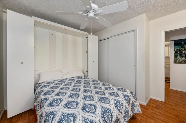 bedroom featuring ceiling fan, a closet, a textured ceiling, and hardwood / wood-style floors