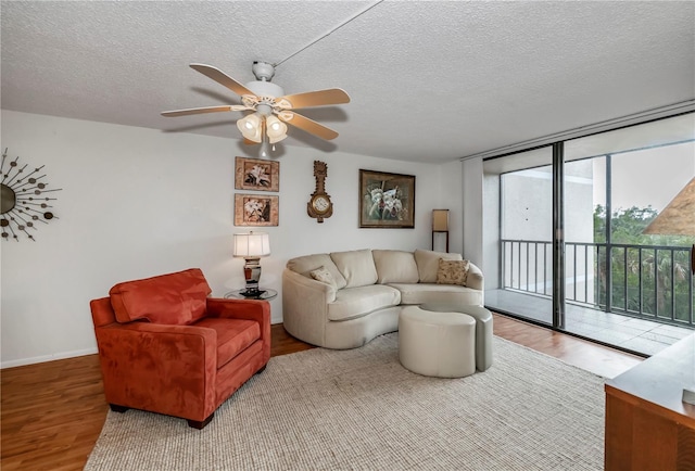 living room with ceiling fan, a textured ceiling, and hardwood / wood-style floors