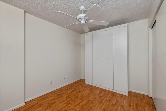 unfurnished bedroom with ceiling fan, a textured ceiling, and light hardwood / wood-style floors