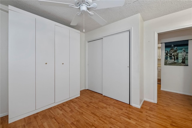 unfurnished bedroom with ceiling fan, light wood-type flooring, and a textured ceiling