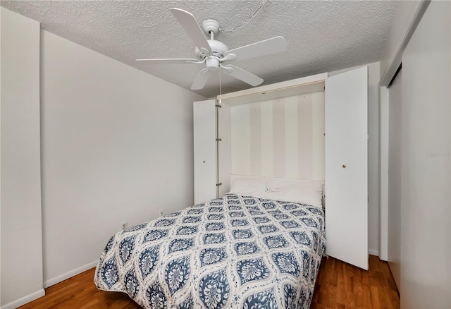 bedroom featuring a textured ceiling, ceiling fan, and dark hardwood / wood-style floors