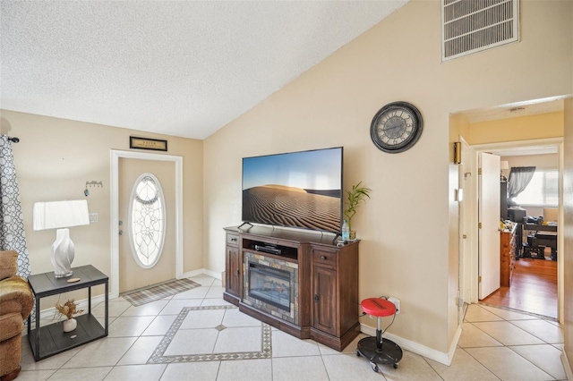 tiled living room with a textured ceiling and vaulted ceiling