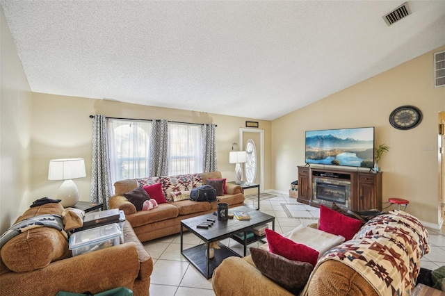 living room with vaulted ceiling, a textured ceiling, and light tile patterned floors