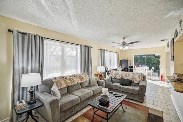 tiled living room featuring a textured ceiling and ceiling fan