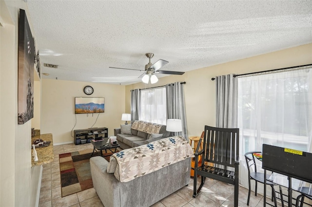 tiled living room with a textured ceiling and ceiling fan