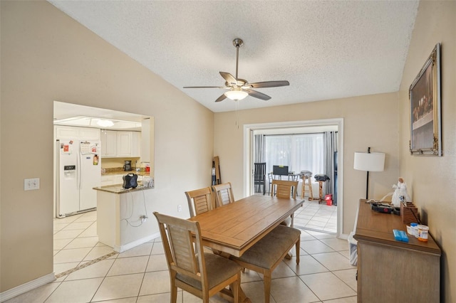 dining room with vaulted ceiling, a textured ceiling, ceiling fan, and light tile patterned floors