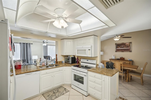 kitchen with white appliances, kitchen peninsula, and white cabinetry