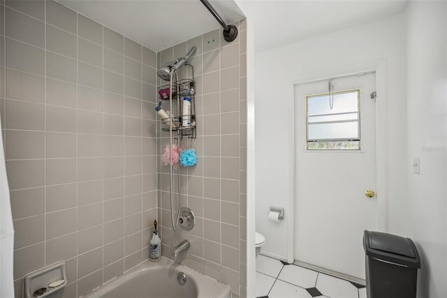 bathroom featuring tiled shower / bath combo and toilet