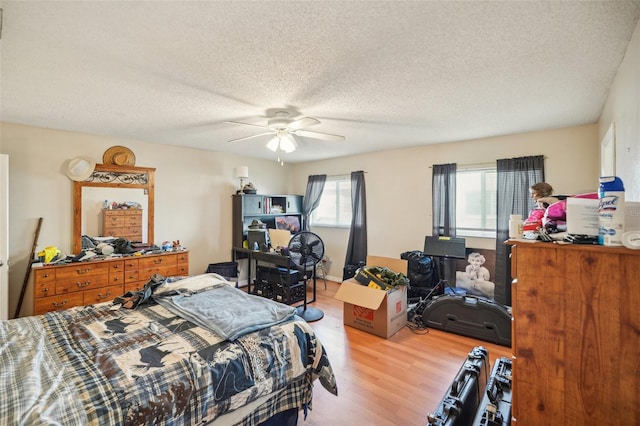 bedroom featuring hardwood / wood-style floors, a textured ceiling, and ceiling fan