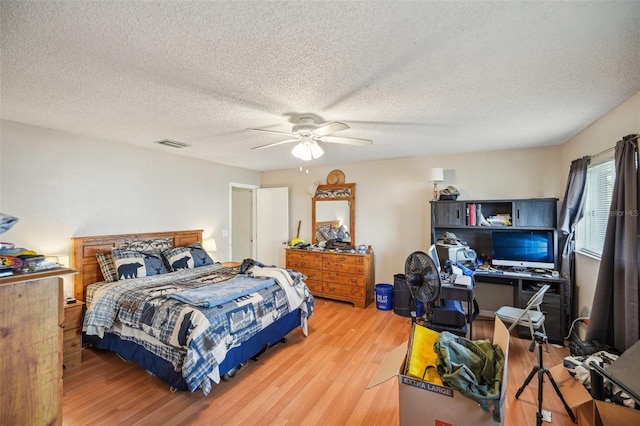 bedroom with hardwood / wood-style floors, a textured ceiling, and ceiling fan