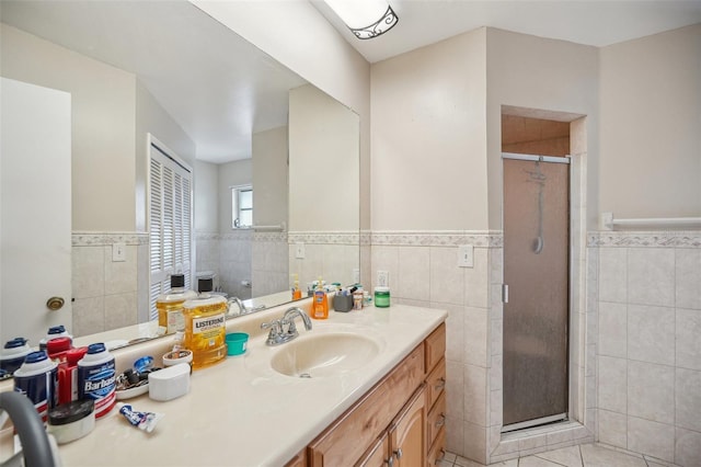 bathroom featuring tile walls, walk in shower, vanity, and tile patterned floors