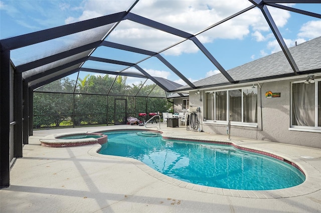 view of pool with a patio, glass enclosure, and an in ground hot tub