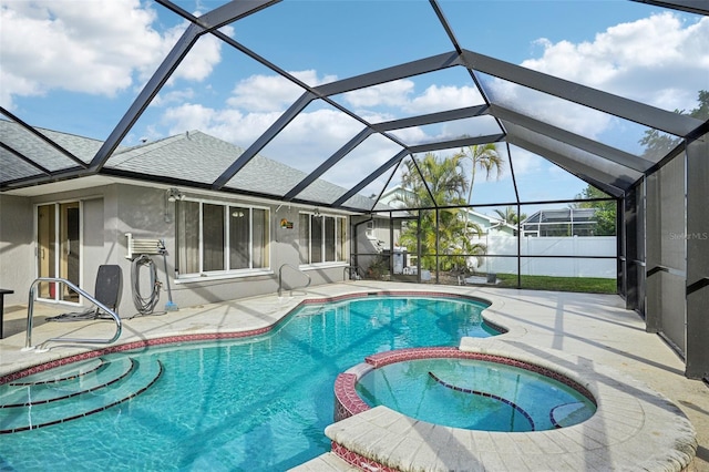 view of pool with an in ground hot tub, glass enclosure, and a patio