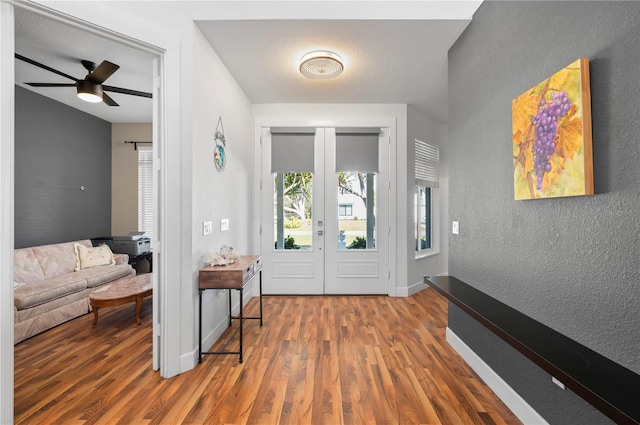 entryway with a textured ceiling, ceiling fan, wood-type flooring, and french doors