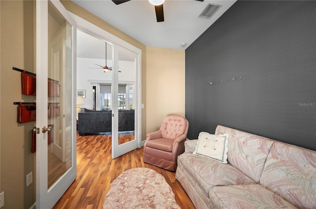 living room featuring ceiling fan, french doors, and light hardwood / wood-style floors